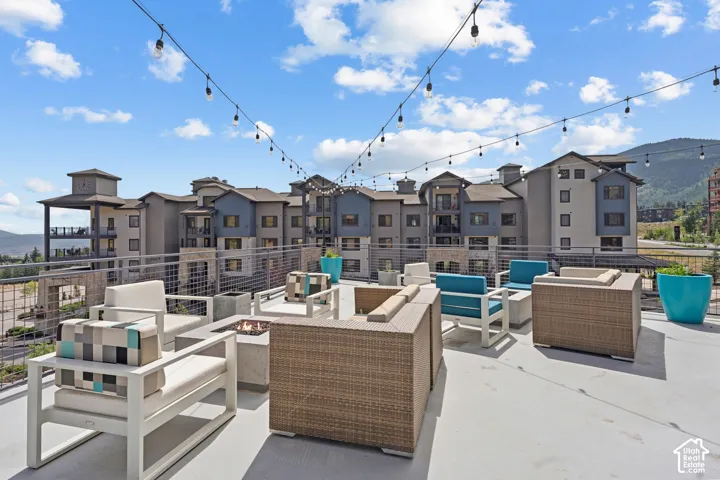 Rooftop terrace with integrated fire pit, string lighting, and metal railing