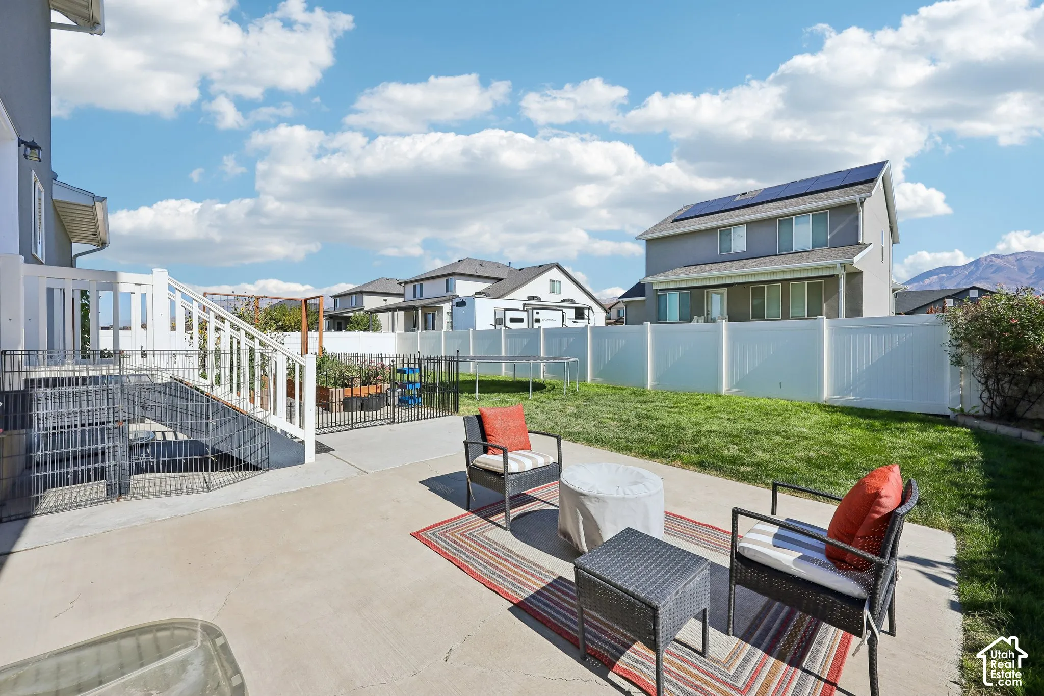 Concrete patio with white railing leading to the lower level