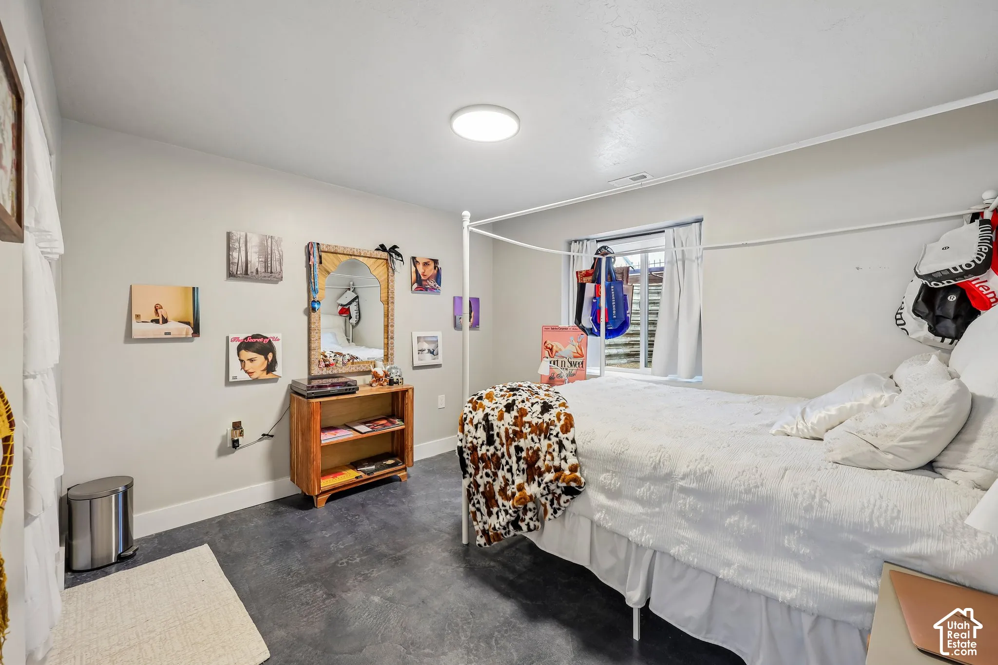 Recessed window with white drapes, light gray walls, dark gray concrete-finish flooring, and flush-mount ceiling light