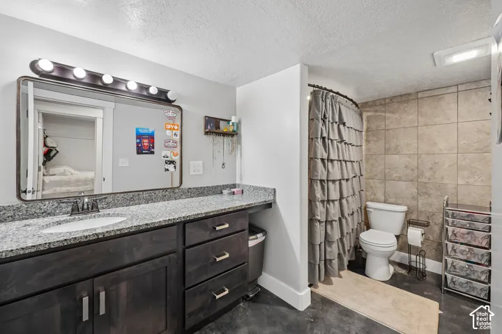 Vanity with a granite-style countertop, undermount sink, and wood-finish cabinetry