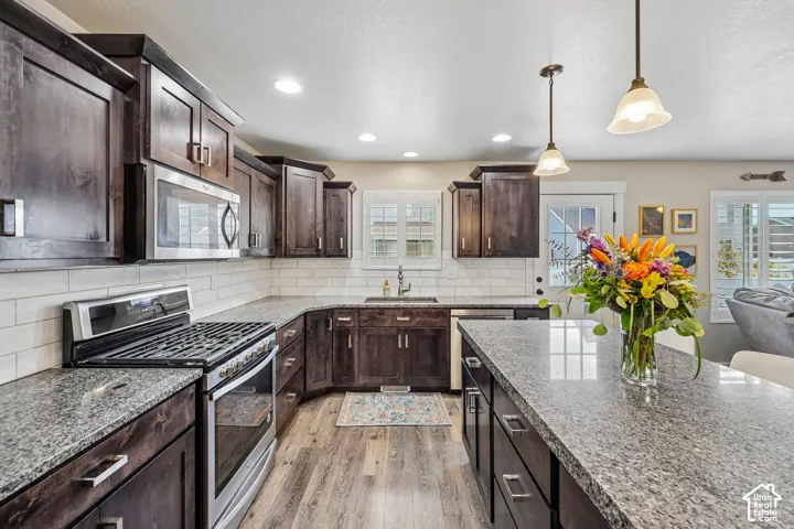 Kitchen featuring wood-finish flooring, dark wood cabinetry, and light-toned countertops