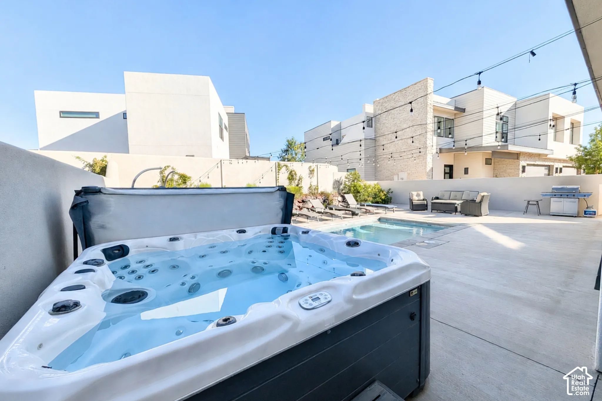 Private outdoor space featuring a hot tub, swimming pool, and concrete patio