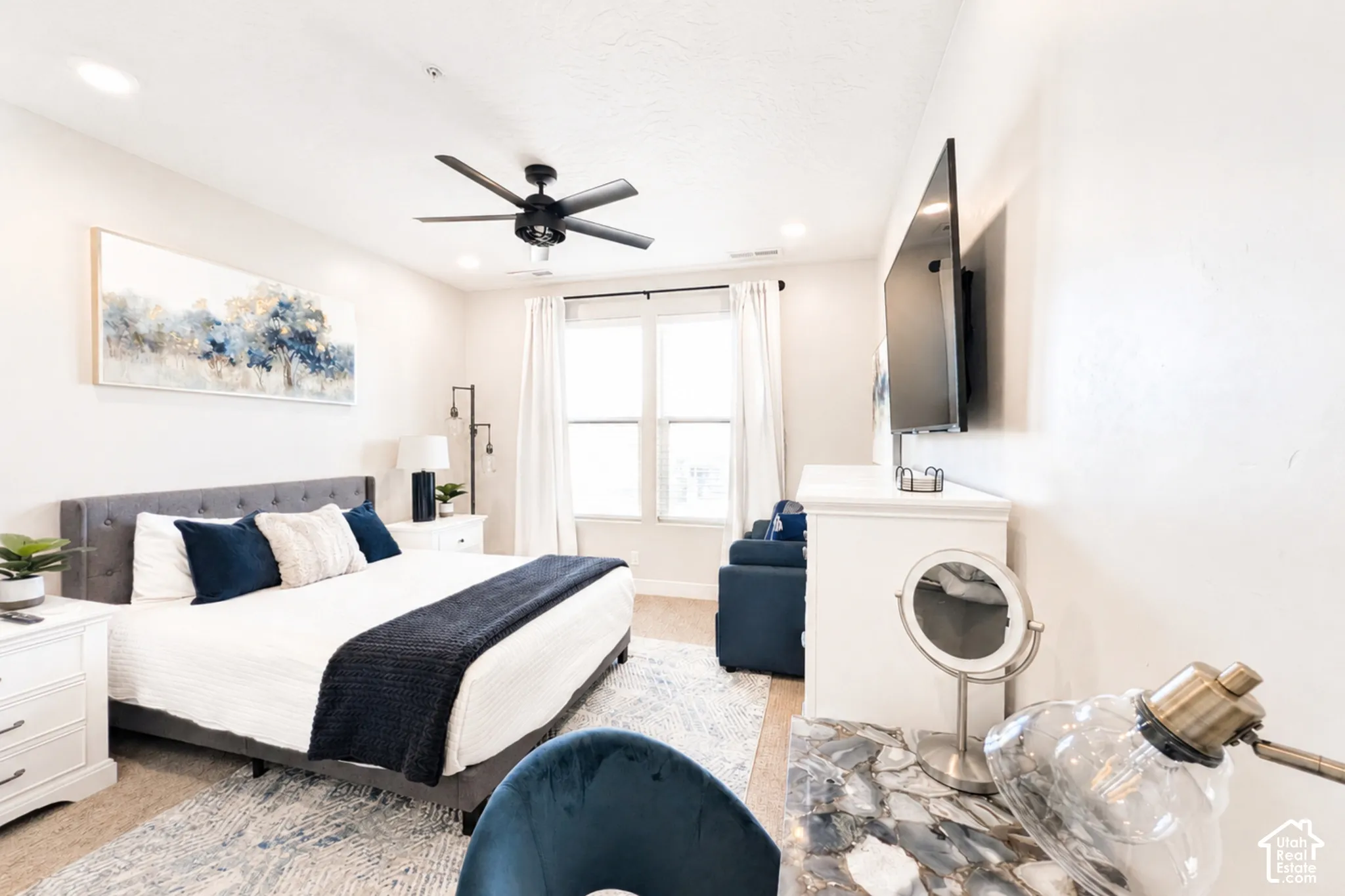 Recessed lighting, ceiling fan, large window, built-in wall-mounted television, and wood-finish flooring