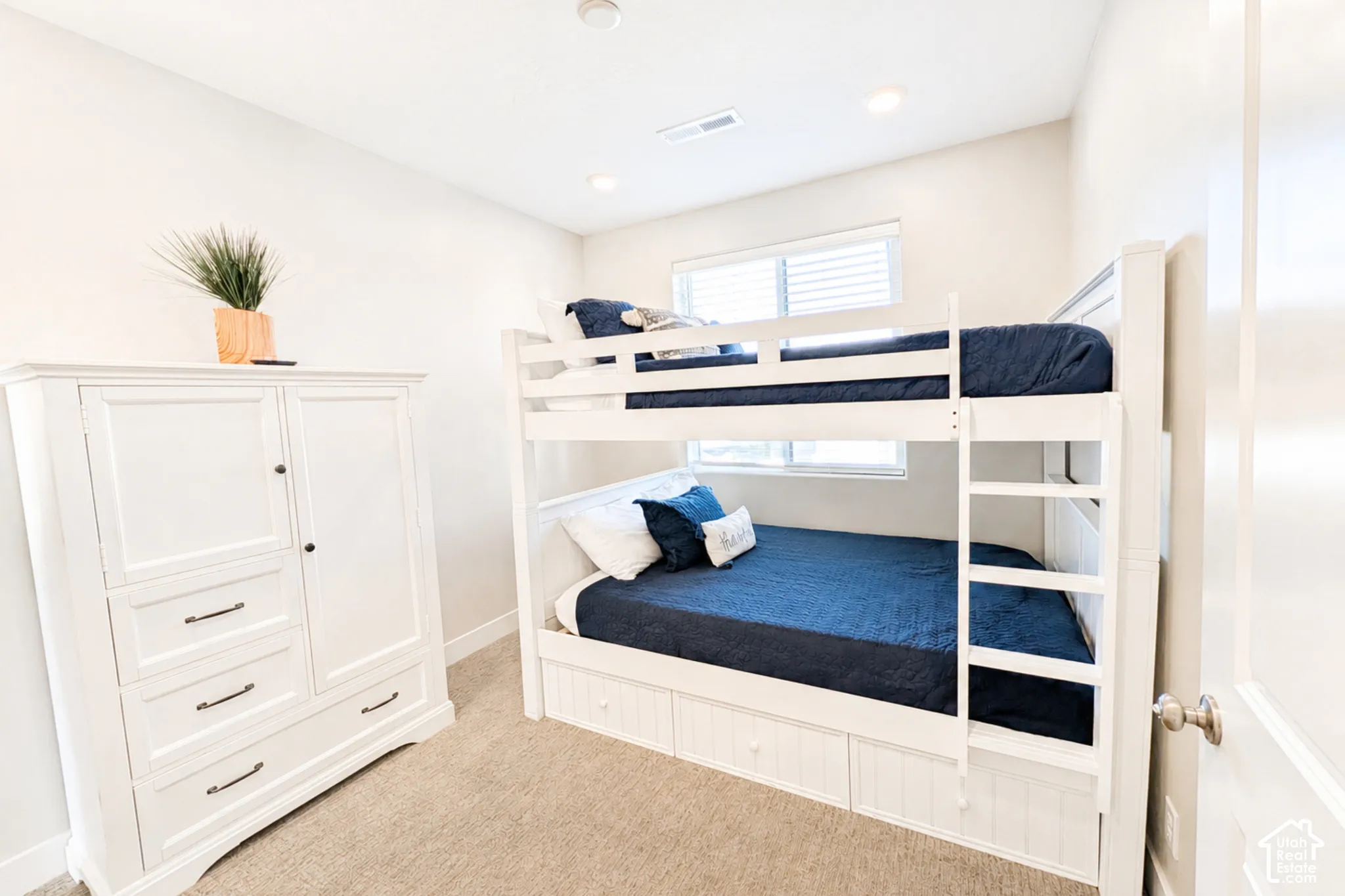 Recessed lighting, bunk beds with integrated storage, white window blinds, and neutral wall paint