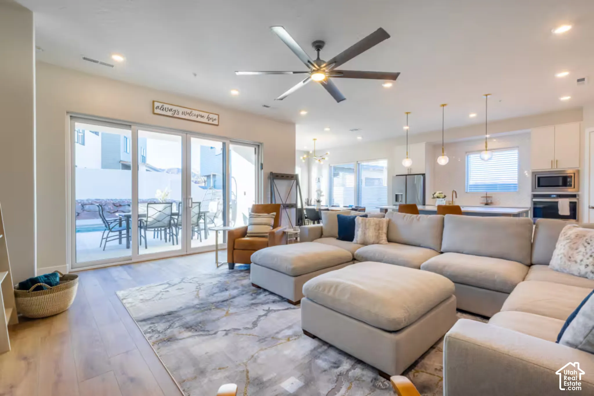 Open-concept living area featuring wood-finish flooring, recessed lighting, and a modern ceiling fan