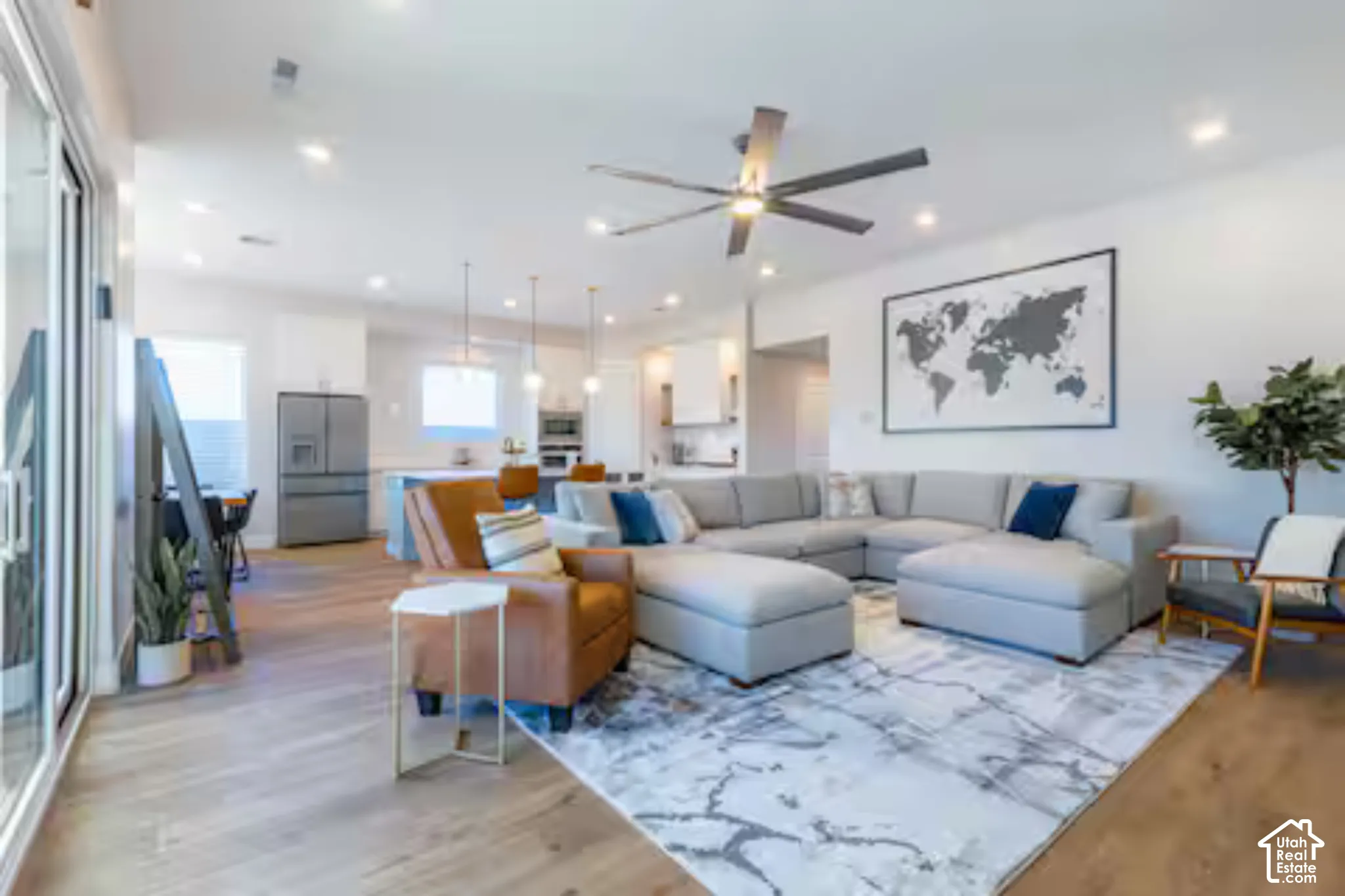 Open-concept living area with wood-finish flooring, recessed lighting, and a ceiling fan