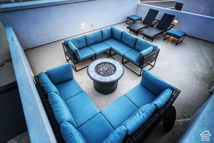 Expansive outdoor patio with concrete flooring, low wall enclosures, and integrated wall lighting