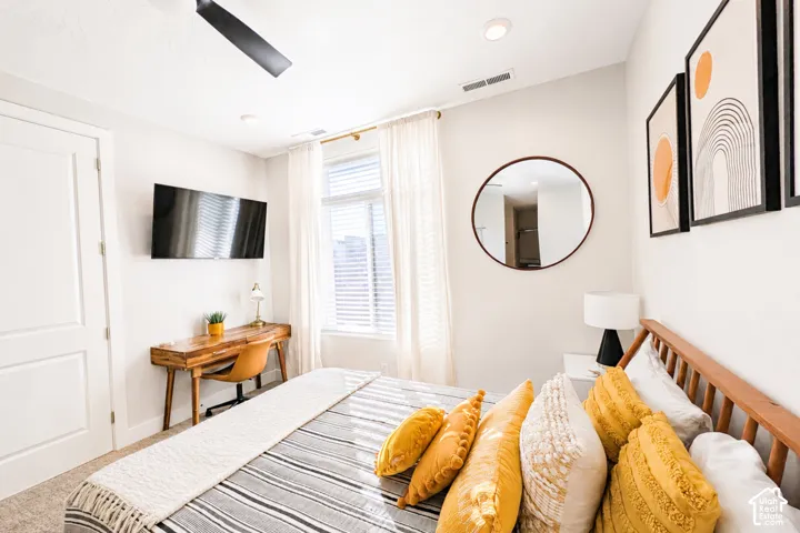 Recessed lighting, ceiling fan, natural light from a window with blinds, and a built-in wall-mounted television