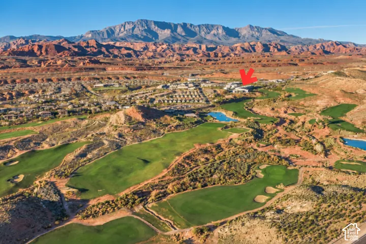 Aerial perspective showcasing a golf course, residential areas, and mountain scenery