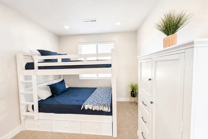Recessed ceiling lighting, window with blinds, light-toned walls, and carpet flooring