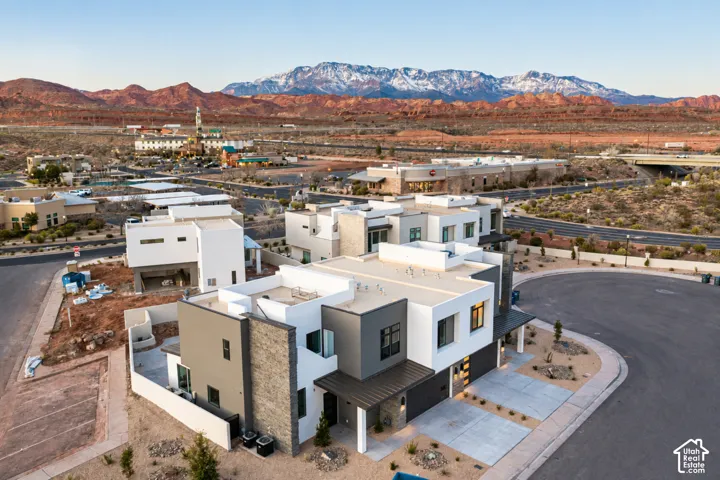 Modern architectural styling with flat rooflines, a multi-textured facade featuring stone veneer and smooth stucco, and a covered entry