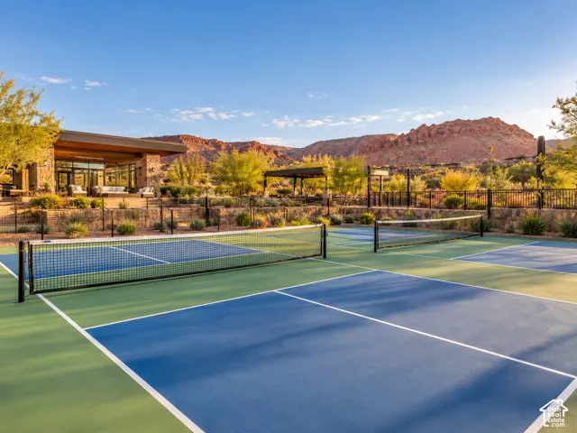 Multiple outdoor courts with blue and green surfaces, featuring white boundary lines and black nets