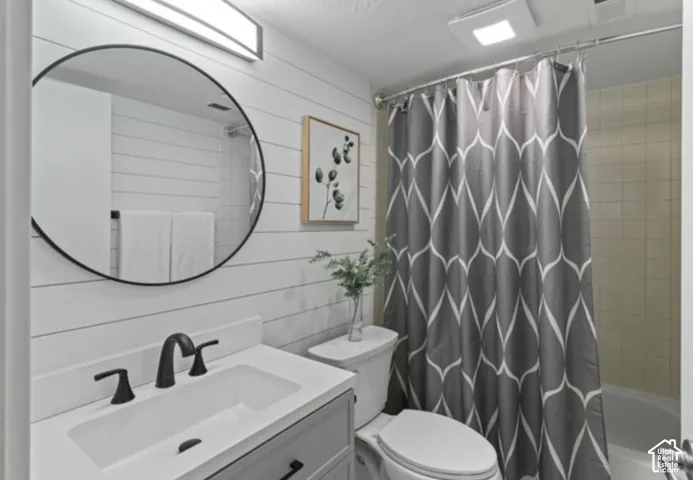 Bathroom featuring a vanity with an integrated sink, matte black faucet, and a round mirror