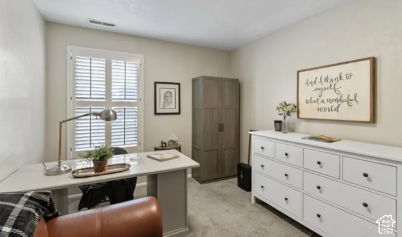 Window with louvered shutters, light beige wall paint, built-in wardrobe, and carpeted flooring