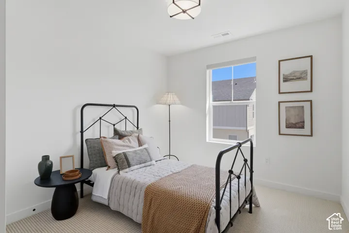 Carpeted flooring, white painted walls, and a single window with a framed exterior view