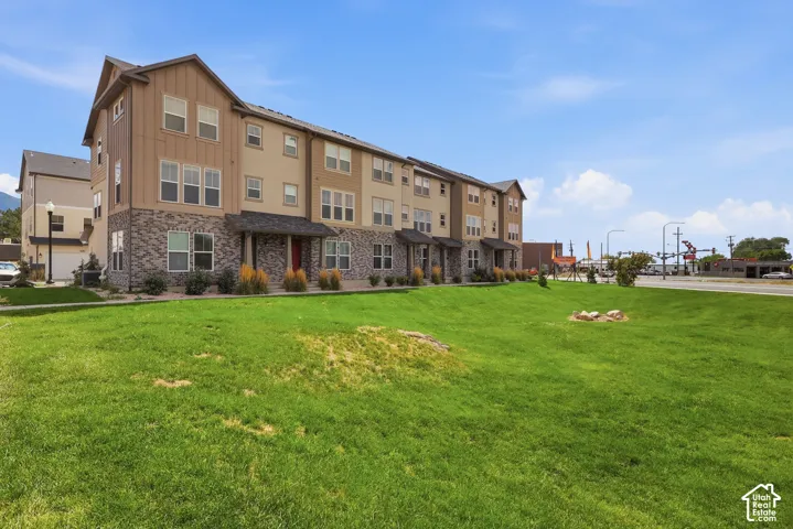 Townhome exterior featuring stone veneer and vertical siding accents
