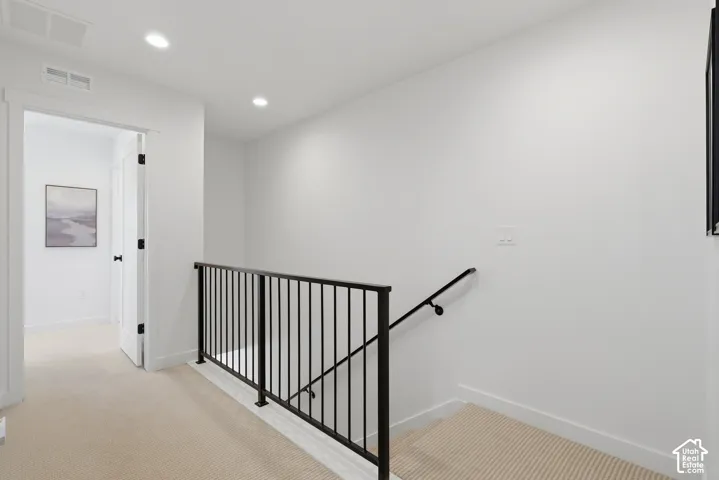 Upper-level hallway with recessed lighting and neutral wall paint