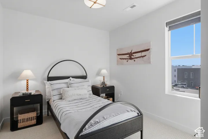 Recessed lighting, wall-to-wall carpeting, and a window with roller shade