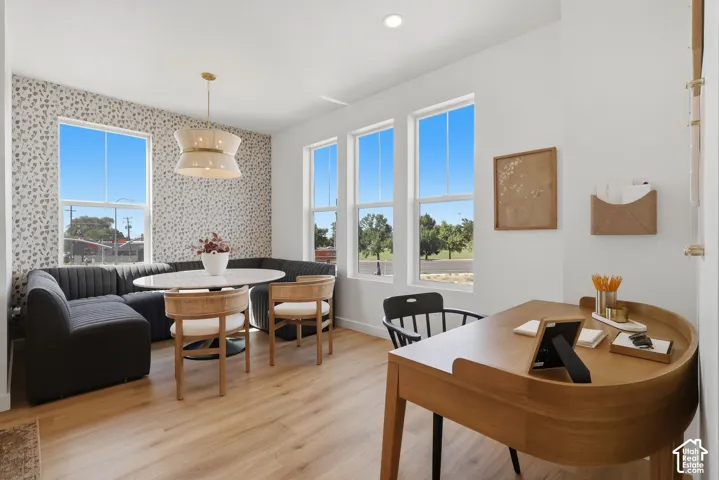 Wood-finish flooring throughout, multiple windows providing natural light, recessed lighting, and a contemporary light fixture