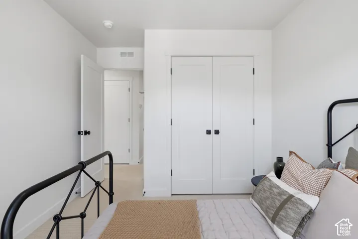 White interior walls, white paneled doors, black door hardware, and light-toned carpeting