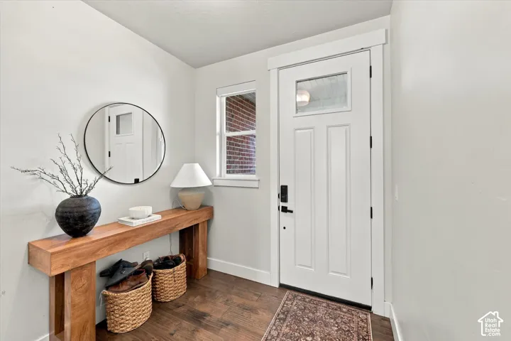 White paneled entry door with frosted glass insert, matte black hardware, and sidelight window