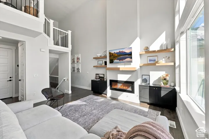 Double-height living space featuring dark wood-finish flooring