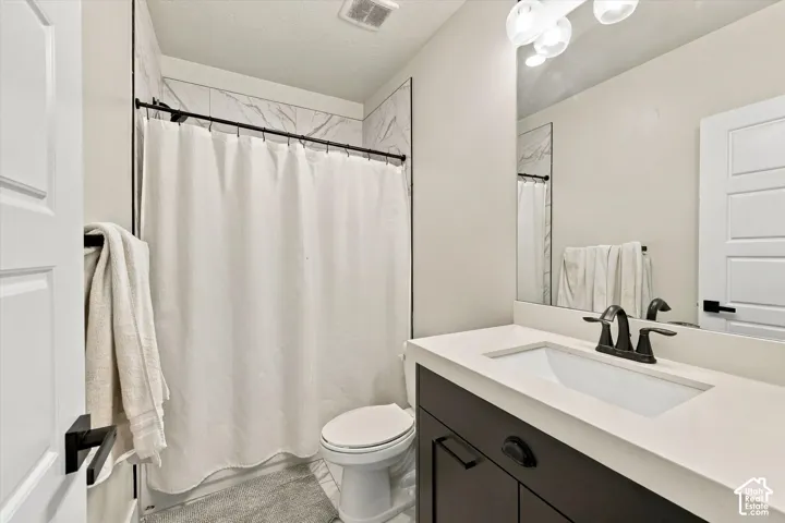 Dark wood-finish vanity with a light countertop, integrated sink, and matte black faucet