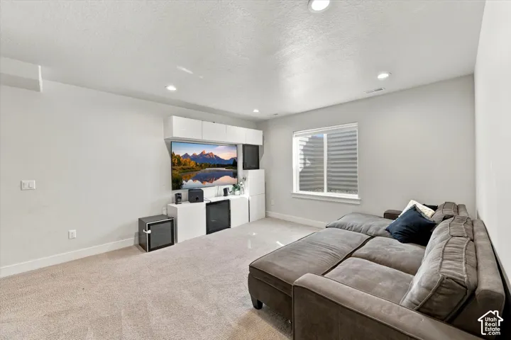 Recessed lighting illuminates the room, featuring a built-in media center with integrated cabinetry