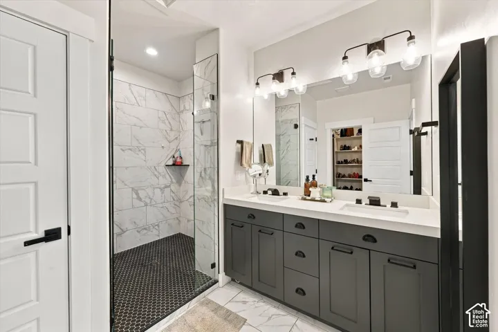 Dual vanity with white countertop, undermount sinks, and dark cabinetry