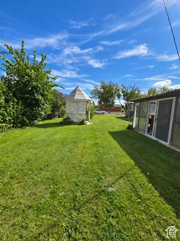 Expansive lawn featuring a white gazebo and mature landscaping