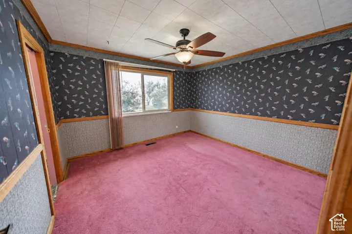 Recessed ceiling with acoustic tiles, wood-finish trim, window with blinds, and a ceiling fan with integrated lighting