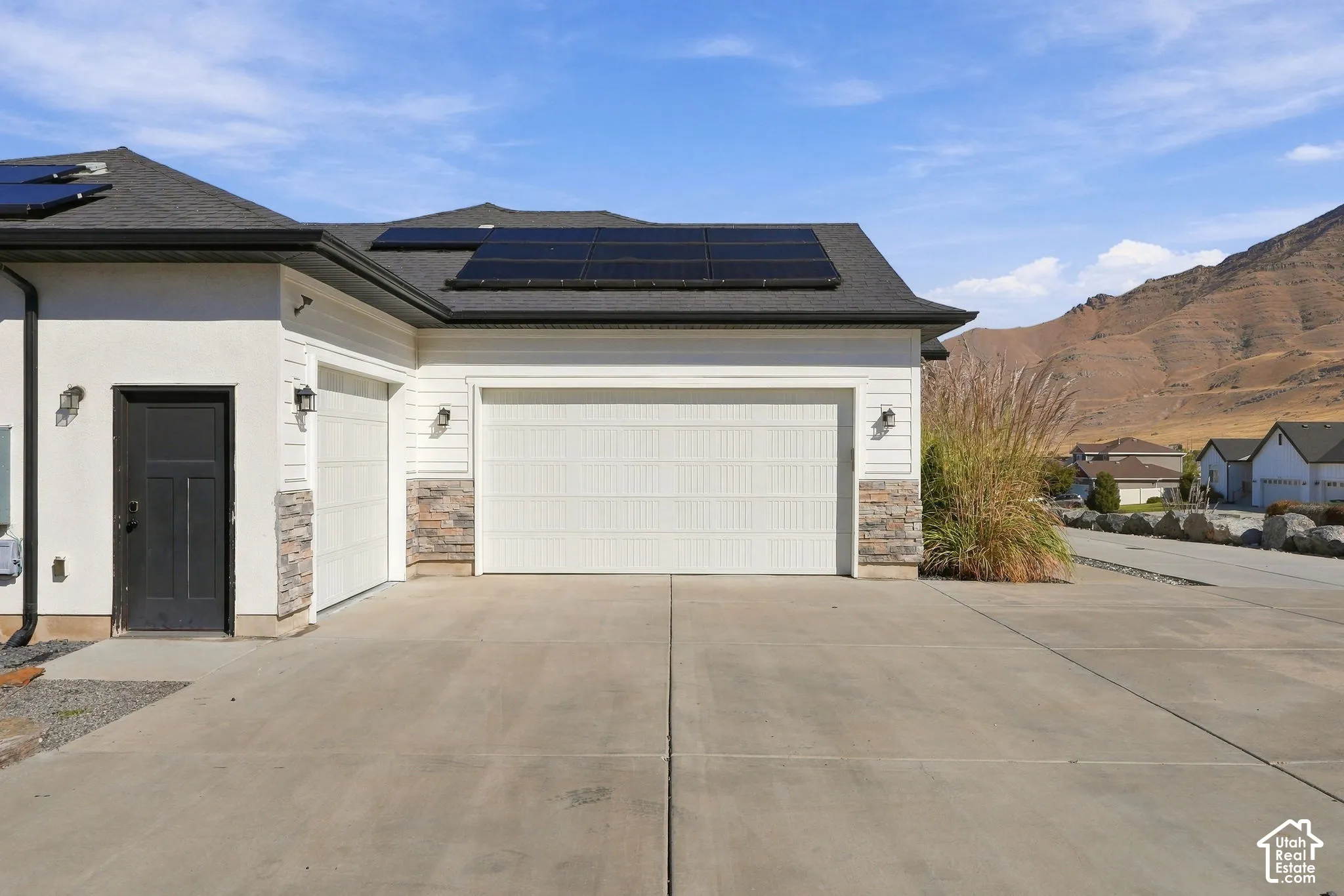Concrete driveway leading to a two-car garage with a separate single-car garage