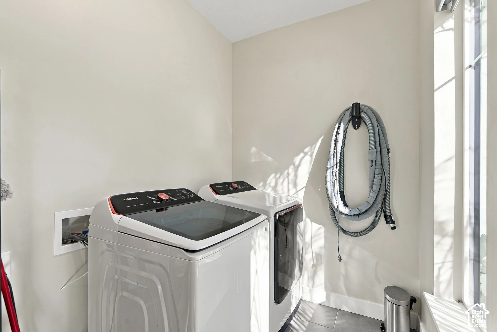 Laundry area featuring a large window, light-toned walls, and tile flooring