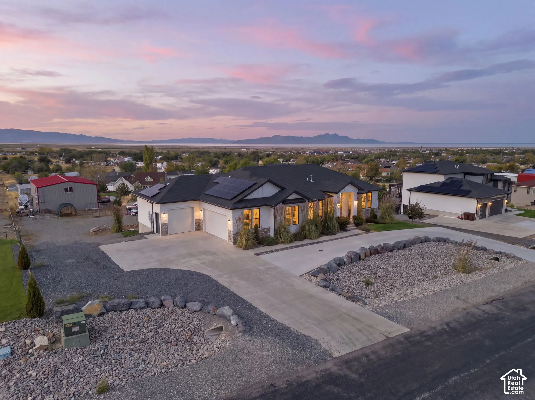 Modern home with solar panels, an attached two-car garage, and a concrete driveway