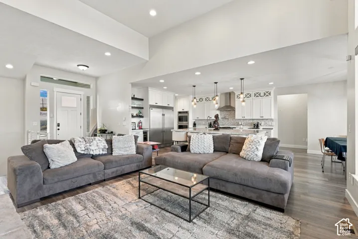Open-concept living area with vaulted ceilings, recessed lighting, and wood-finish flooring