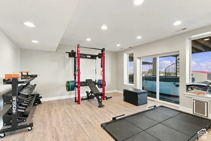 Recessed lighting, wood-finish flooring, sliding glass door, and multiple windows