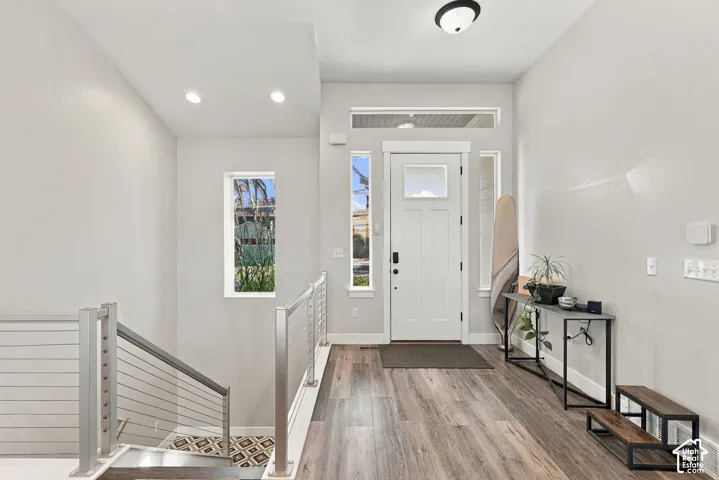 Entryway with wood-finish flooring, recessed lighting, and a white paneled door with transom window