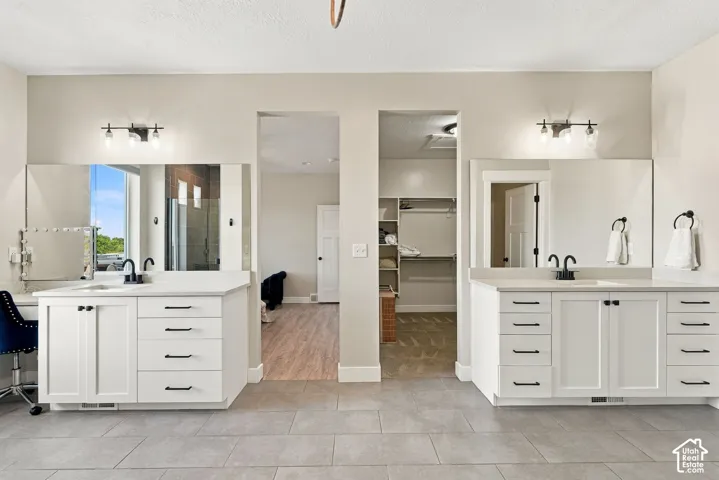 Double vanity with white cabinetry, matte black hardware, and integrated sinks