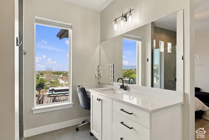 White vanity with a light-toned countertop, integrated sink, and matte black faucet