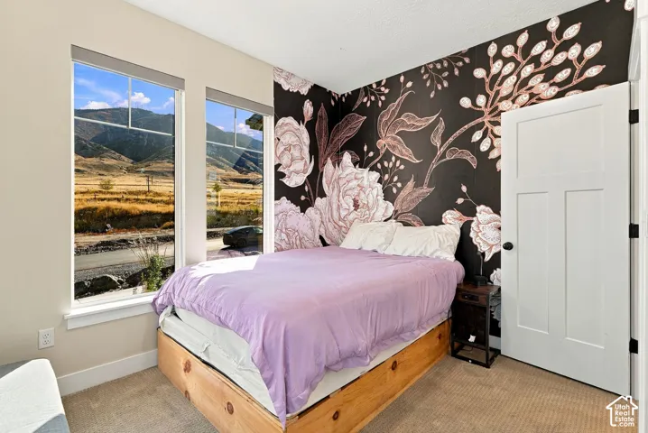 Dual vertical windows, floral accent wall, and a three-panel interior door