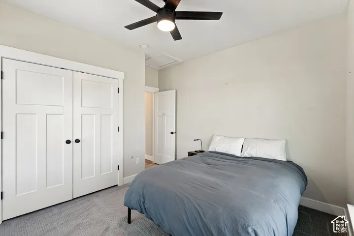 Carpeted room featuring a ceiling fan with integrated lighting, white paneled doors, and white trim