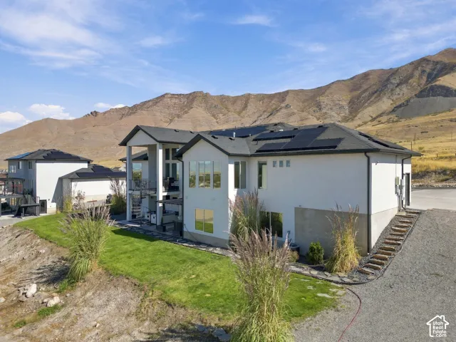 Contemporary exterior with a white stucco finish, dark roof, and solar panels