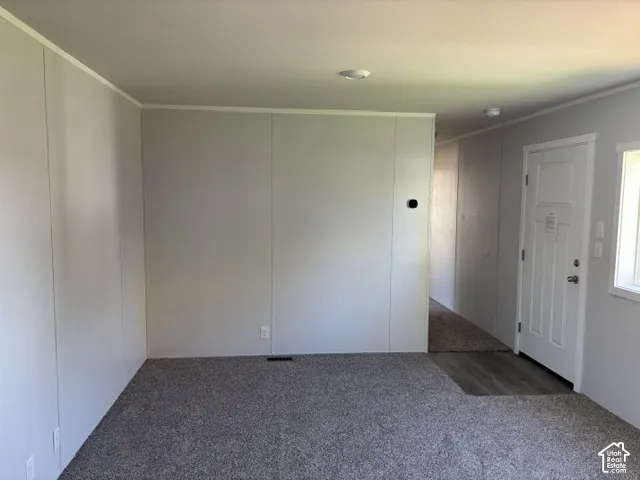 Textured panel walls, recessed ceiling lighting, and wood-finish flooring at entry