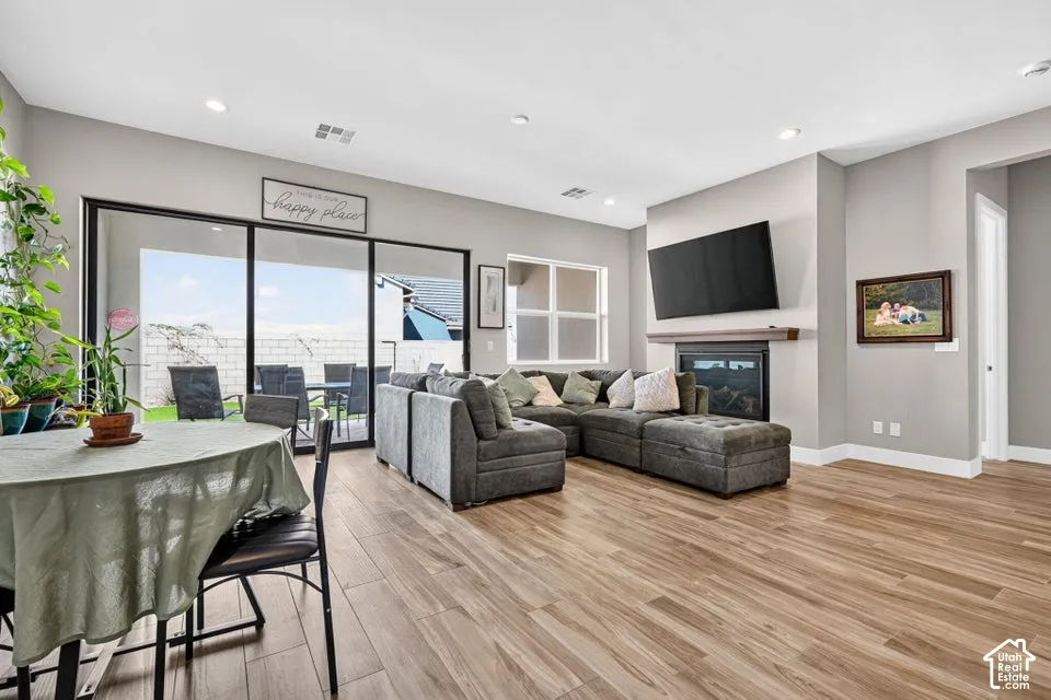 Wood-finish flooring throughout, recessed lighting, and a built-in fireplace with mantel