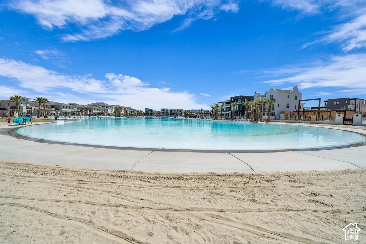 Expansive lagoon with a concrete perimeter, surrounded by multi-story residential structures and mature palm trees