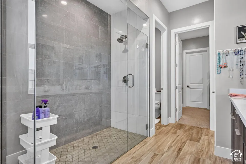 Glass-enclosed shower with large format wall tiles, a tiled shower pan, and a rain shower head