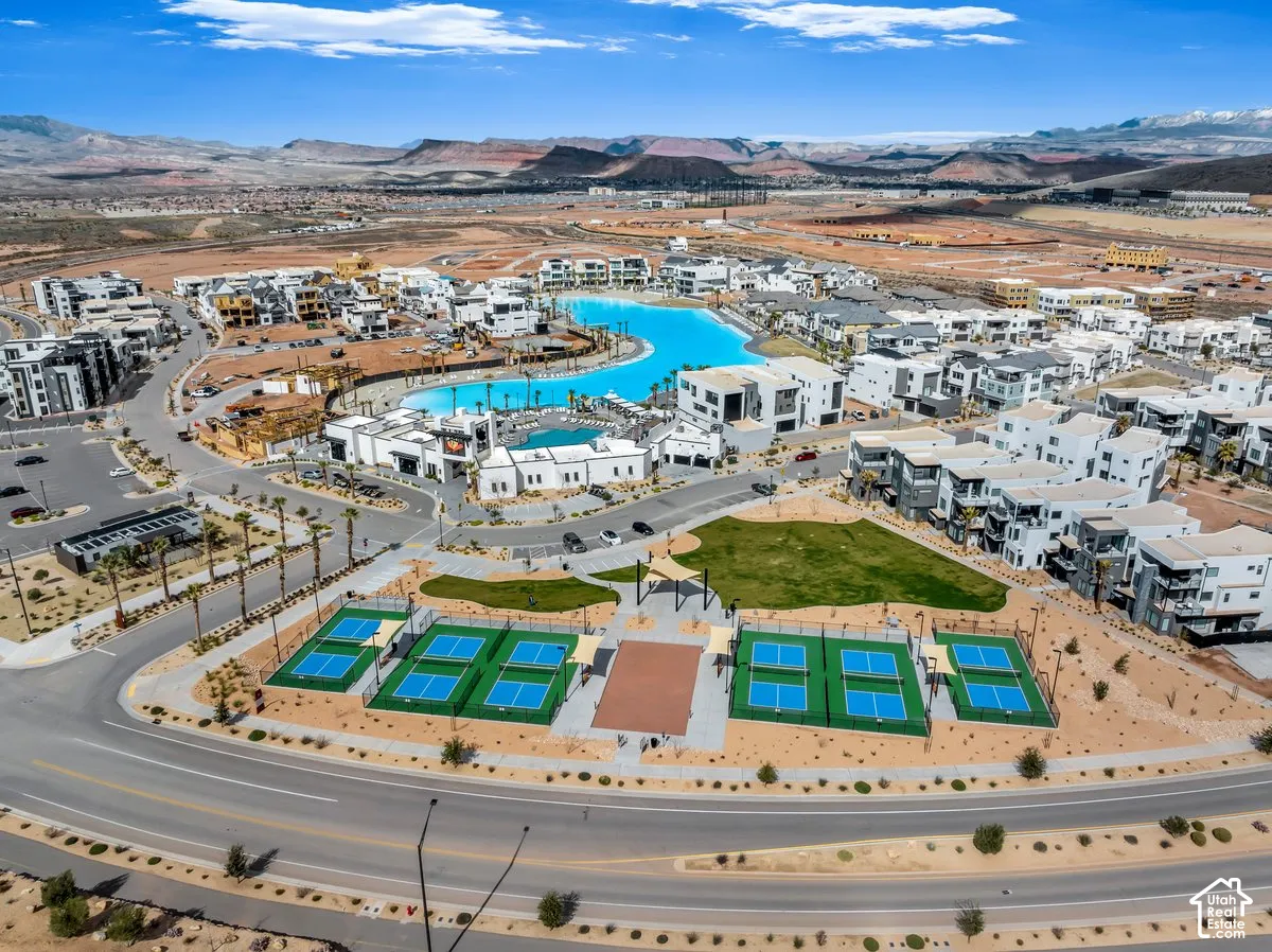 Community featuring a large recreational lagoon, multiple tennis courts, a central green space, and modern residential buildings