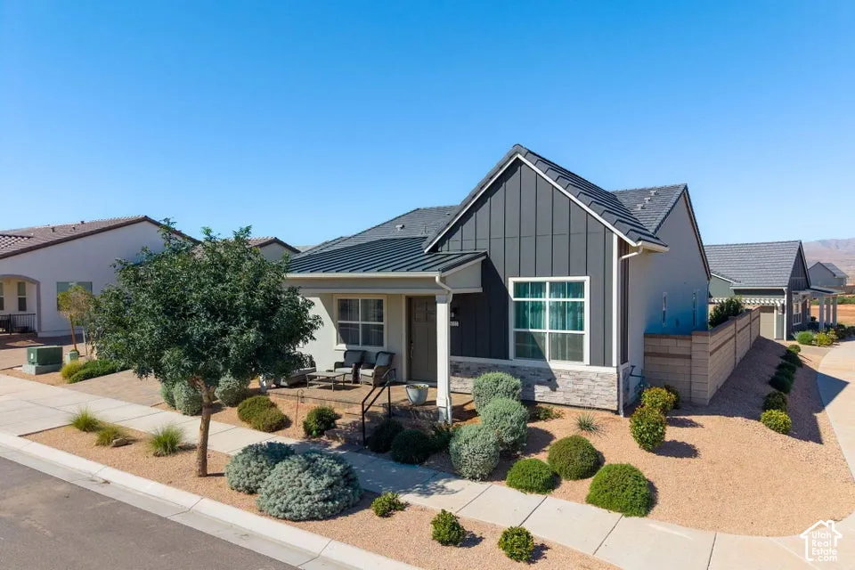Modern exterior featuring board and batten siding, stone veneer accents, and a covered front porch