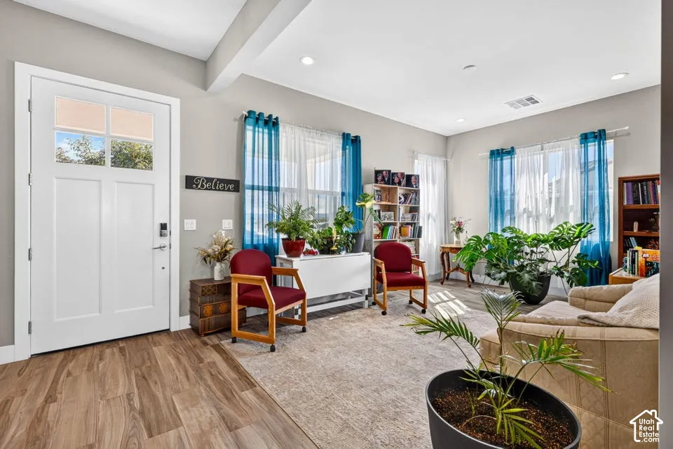 Entryway featuring wood-finish flooring and a white paneled door with upper glass inserts