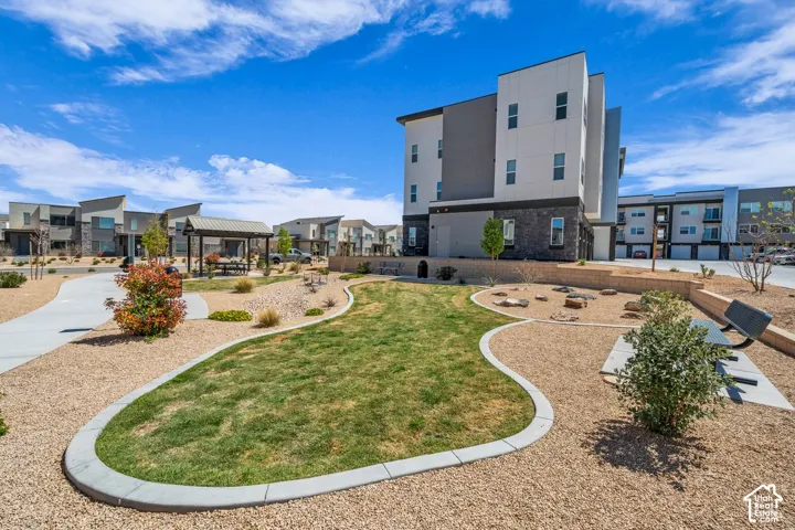 Landscaped grounds with a curvilinear lawn, gravel paths, and a shaded picnic area